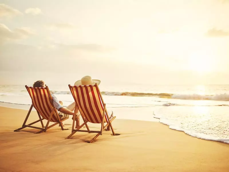 retirement wishes couple watching sunset in beach chairs